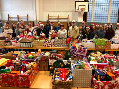 Weihnachten für alle dank der Spendenbereitschaft der Paderborner - sie sagen Danke: Landrat Manfred Müller (hinten mittig im Bild mit Paket in der Hand), links neben ihm Uwe Hoffmann, Vorsitzender der Tafel Paderborn, und die vielen ehrenamtlichen Helferinnen und Helfer und Schülerinnen und Schüler des Gymnasiums St. Michael freuen sich über die die vielen gespendeten Weihnachtspäckchen, Foto: Amt für Presse- und Öffentlichkeitsarbeit, Kreis Paderborn, Michaela Pitz Weihnachtspäckchen der Tafel Paderborn